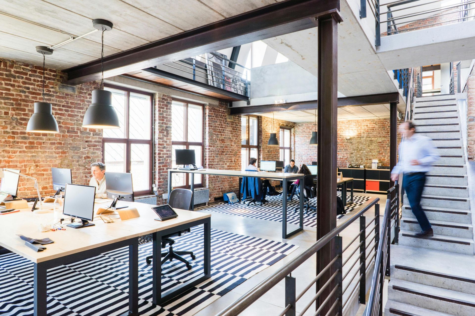 Spacious and stylish open-plan office with loft and industrial aesthetic.